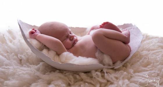 Babies photographed cuddled up in molds of their moms' pregnant bellies