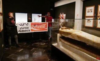 Activists throw a liquid similar to oil in a showcase of the Egyptian Museum of Barcelona
