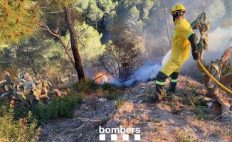 Firefighters fight a forest fire in Vallirana