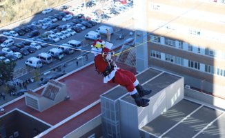 Santa Claus jumps on a zip line to greet the pediatric patients admitted to Can Ruti